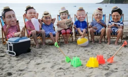 Des militants avec des masques à l'effigie des dirigeants du G7 lors d'une action menée par Oxfam, à Falmouth, le 11 juin 2021