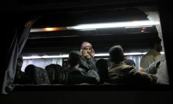 Des rebelles et civils syriens évacués de leur ancien fief dans la Ghouta orientale après des semaines de bombardements du régime, dans un bus arrivant à Qalaat al-Madiq, le 31 mars 2018, étape avant leur destination finale dans la province d'Idleb au nord-ouest de la Syrie.
