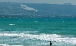 Une personne prend un bain de mer face au village d'El Mansouri, dans le sud du Liban, pendant un bombardement israélien le 22 mai 2026