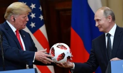 Le président russe Vladimir Poutine offre un ballon du Mondial au président américain Donald Trump, lors d'une conférence de presse commune, le 16 juillet 2018 à Helsinki   