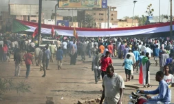 Des manifestants ont dressé un gigantesque drapeau soudanais lors d'une manifestation à Omdourman, la ville jumelle de Khartoum, pour réclamer le retour du pouvoir civil au Soudan, le 13 décembre 2021