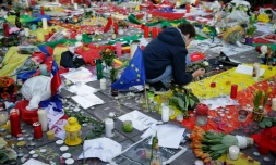 Un garçon allume une bougie en hommage aux victimes des attentats de Bruxelles, Place de la Bourse, le 23 mars 2016