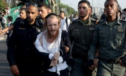 La police israĂ©lienne arrĂȘte un manifestant ultra-orthodoxe qui manifeste contre l'obligation de service militaire, Ă Bnei Brak, le 20 juin 2024