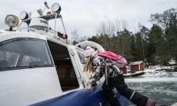 Une écolière embarque à bord d'un aéroglisseur pour rentrer de l'école, le 3 mars 2026 à Paragas, en Finlande