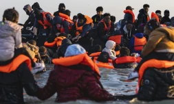 Des migrants montent à bord d'un bateau de passeurs pour traverser la Manche, au large de la plage de Gravelines, le 16 juin 2025 dans le Nord