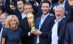 Le président Emmanuel Macron avec le capitaine des Bleus Hugo Lloris brandissent le trophée de champions du monde à l'Elysée, lors d'une réception le 16 juillet 2018