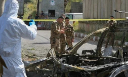 Des membres des forces de sécurité libanaises et des experts médico-légaux inspectent une voiture détruite par une frappe aérienne israélienne, près de la ville côtière de Damour, au sud de Beyrouth, le 22 avril 2025
