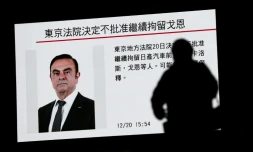 Un piéton passe devant un écran sur lequel est diffusé un programme sur l'ex PDG de Renault et de l'Alliance Renault-Nissan Carlos Ghosn, à Tokyo, le 20 décembre 2018