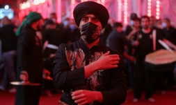 Un fidÚle chiite portant un masque de protection participe à un rituel commémorant le martyre de l'imam Hussein, dans son mausolée à Kerbala, dans le centre de l'Irak, le 29 août 2020