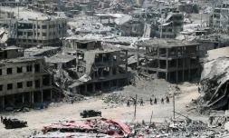 Les forces irakiennes marchent devant des bâtiments détruits de la ville de Mossoul (Irak), le 9 juillet 2017