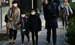Mayumi Iijima se rend à son travail accompagnée de ses deux enfants, privés d'école pendant l'épidémie du nouveau coronavirus, le 6 mars 2020 à Tokyo 