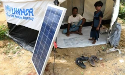 Des réfugiés Rohingyas attendent qu'une lanterne se charge grâce à l'énergie solaire, dans un camp de Kutupalong au Bangladesh, le 7 octobre 2017