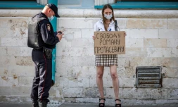 Une jeune femme brandit une pancarte "Liberté pour Roman Protassevitch" devant l'ambassade du Bélarus à Moscou le 25 mai 2021