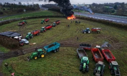 Des agriculteurs allument un feu alors qu'ils participent, avec leurs véhicules, à un blocage d'autoroute, à Poilley, dans l'ouest de la France, le 5 janvier 2026