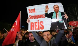 Un soutien du président turc sortant Tayyip Erdogan tient une affiche sur laquelle on peut lire "Nous t'aimons, Reis" pendant un rassemblement devant son parti, l'AK, à l'issue du premier tour des élections générales à Ankara, le 15 mai 2023