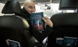 Chauffeur VTC et écrivain, Brahim Kermaoui pose avec son livre "l'Enfant égaré" à AsniÚres-sur-Seine, au nord-ouest de Paris, le 13 décembre 2017