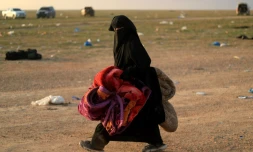 Une femme portant des couvertures est photographiée après avoir fui le dernier bastion du groupe Etat islamique (EI) dans l'est de la Syrie, le 22 février 2019