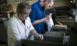 Un jeune homme, alors employé avec un contrat de génération, travaille aux côtés d'un employé plus âgé, le 25 mars 2013 dans un atelier d'assemblage d'optique à Mitry-Mory, en Seine-et-Marne