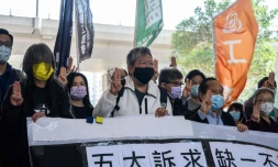 (g-d) Les militants prodémocratie Leung Kwok-hung, alias "Long Hair", Lee Cheuk-yan, Albert Ho et Cyd Ho font le salut à trois doigts à leur arrivée au tribunal de West Kowloon, le 16 février 2021 à Hong Kong