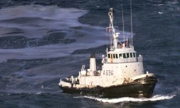 Un remorqueur de haute mer de la Marine française, le Buffle, équipé d'un "transec" pour tenter d'aspirer directement le fioul lourd, travaille le 15 décembre 1999 sur la nappe de 10.000 à 12.000 tonnes, après le naufrage du pétrolier maltais Erika au large du sud-Finistère
