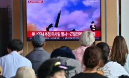 Des personnes regardent un écran de télévision diffusant un bulletin d'information sur un test de missile nord-coréen, dans une gare de Séoul, le 12 juillet 2023