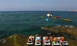 Des Libanais prennent un bain de soleil au bord de la mer à Anfeh, au nord de Beyrouth, le 23 août 2016