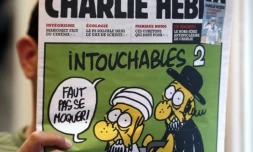 Un homme lit le 19 septembre 2012 le numéro de Charlie Hebdo paru ce jour-là, montrant un juif et un musulman sous le titre "Intouchables 2"