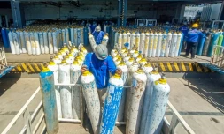 Des employés d'une société fournissant de l'oxygène préparent des bonbonnes pour une distribution à Semarang, dans l'île de Java, en Indonésie, le 6 juillet 2021