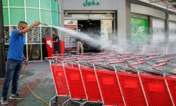Un employé d'un supermarché palestinien désinfecte des chariots à Gaza le 21 septembre 2020
