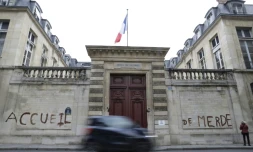 Des militants d'associations de défense des migrants ont tagué "accueil de merde" sur la façade du ministÚre du Logement à Paris le 16 décembre 2017 pour dénoncer les conditions de réception des migrants en France