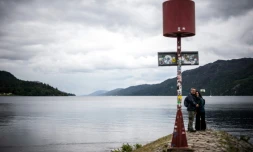 Des visiteurs se prennent en photo devant le Loch Ness, le 6 juillet 2023 en Ecosse