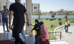 Des membres des forces de sécurité kurdes accompagnent des membre des familles de combattants du groupe Etat Islamique avant de les remettre à des diplomates néerlandais dans la ville syrienne de Qamichli le 5 juin 2021