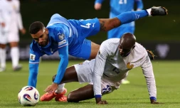 L'Islandais Victor Palsson (en bleu) et le Français Jean-Philippe Mateta sont à la luute en match de qualifications pour le Mondial-2026, le 13 octobre 2025 à Reykjavik