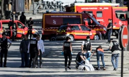 Des membres de la police judiciaire enveloppent le corps de l'auteur de l'attentat raté sur les Champs-Elysées à Paris, le 19 juin 2017