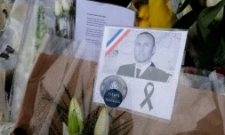 Le portrait du lieutenant-Colonel Arnaud Beltrame parmi des bouquets de fleurs, Ă la gendarmerie de Carcassonne, le 25 mars 2018