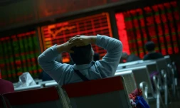 Un investisseur regarde des écrans de cotation dans une société de Bourse le 8 janvier 2016 à Pékin