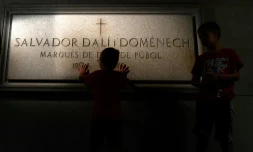 Un enfant touche la tombe de Salvador Dali dans le Théâtre-Musée Dali de Figueras le 18 juillet 2017
