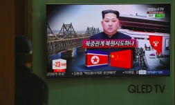 Un passant regarde à la télévision dans une gare de Séoul le 27 mars 2018 des informations évoquant une possible visite en Chine du dirigeant nord-coréen Kim Jong Un