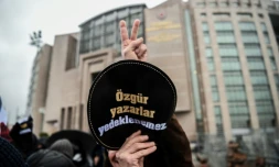 Un homme brandit un écusson "Ecrivains votre liberté n'est pas assurée" le 29 décembre 2016 devant le tribunal où se déroule le procès de la romancière Asli Erdogan