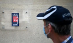 Un homme masqué devant le siège de la Ligue nationale de rugby à Paris le 28 avril 2020