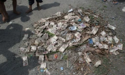Des billets de bolivars empilés parmi des détritus à Puerto Concha, au Vénézuela, le 8 septembre 2021.