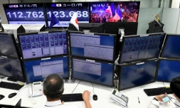 Des courtiers suivent à la télévision la retransmission de l'élection d'Emmanuel Macron à la présidence de la République à la Bourse de Tokyo, le 8 mai 2017