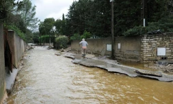 Un homme marche le long d'une rue inondée à Nimes le 10 octobre 2014 à la suite d'intempéries