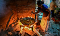 Une femme utilise du bois de chauffage pour cuisiner dans un hĂŽtel de Colombo, le 15 mars 2022