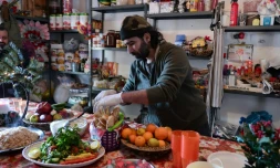 Le chef cuisinier syrien Talal Rankoussi (c) prépare un repas pour les réfugiés du camp de Ritsona, au nord d'Athènes, le 21 décembre 2016 en Grèce