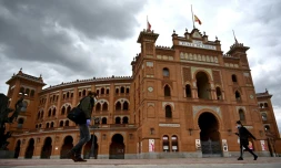 Des passants portant un masque de protection dans une rue de Madrid pendant le confinement instauré pour lutter contre l'épidémie de coronavirus, le 22 avril 2020 en Espagne