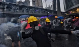 Des manifestants retournent des gaz lacrymogènes contre la police dans la banlieue de Tsuen Wan à Hong Kong le 25 août 2019