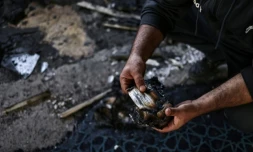 Un homme palestinien tient une page brûlée d'un Coran à l'intérieur de la mosquée Hajja Hamida à Dayr Istiya, dans le nord de la Cisjordanie occupée, le 13 novembre 2025, après une attaque présumée de colons juifs