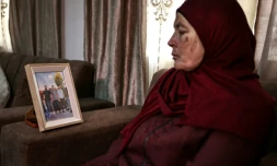 Milia Hamayel, dont le fils Thaer Hamayel a été tué lors d'une attaque de colons israéliens, regarde une photo de son fils défunt dans son village de Abou Falah, au nord-est de Ramallah, le 12 mars 2026