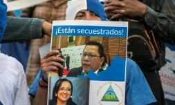 Un Nicaraguayen brandit une pancarte de soutien aux journalistes Miguel Mora et Lucia Pineda, accusés de terrorisme par le régime de Daniel Ortega, lors d'une manifestation le 22 décembre 2018 à San José au Costa Rica